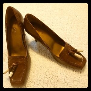 Brown Leather pumps with tassels still wrapped.